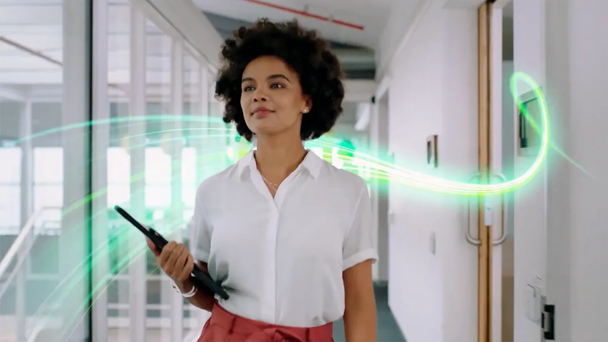 Women with tablet in hand walking inside office