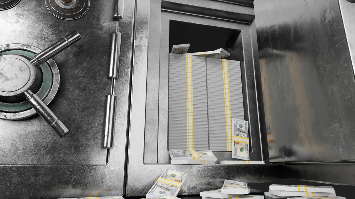 An open metal safe shows stacks of bills inside.