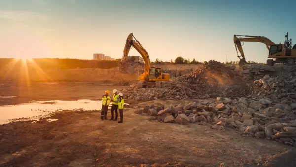 Aerial view of construction site with excavators on a sunny day.