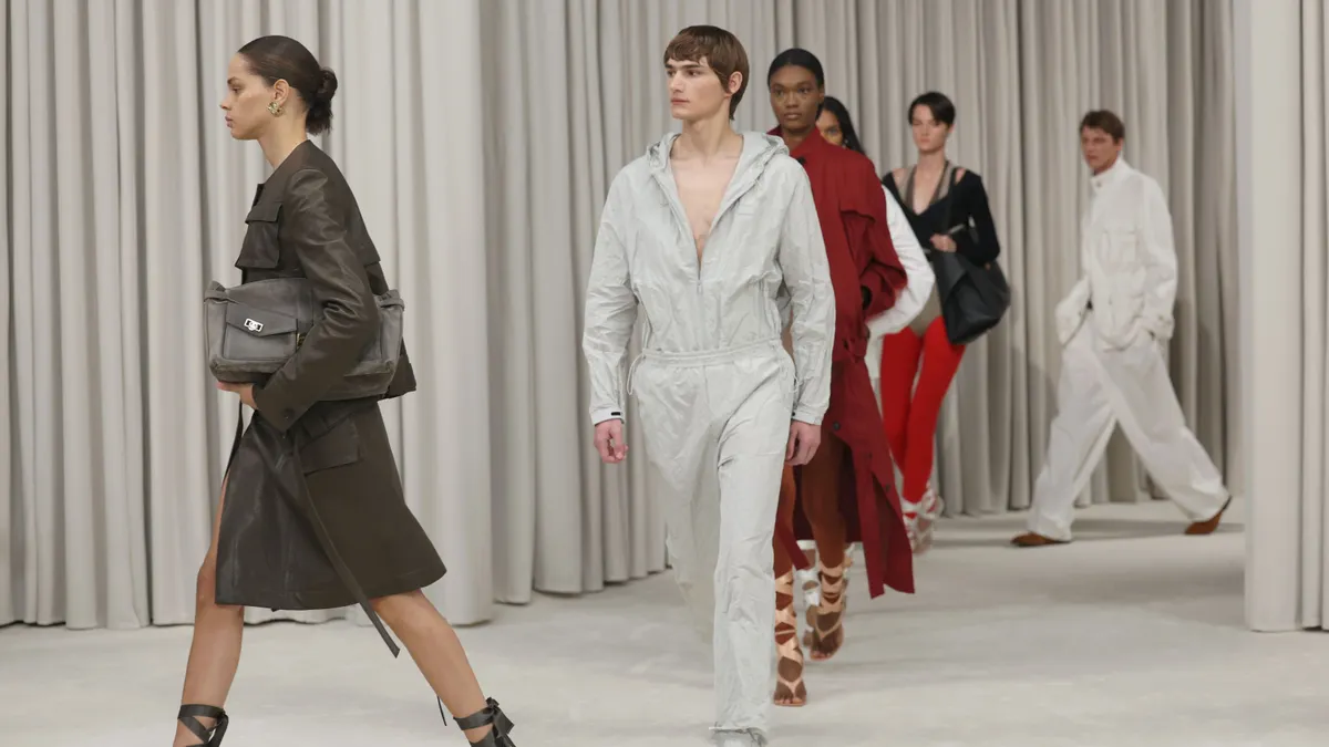 Models walk on a white runway.