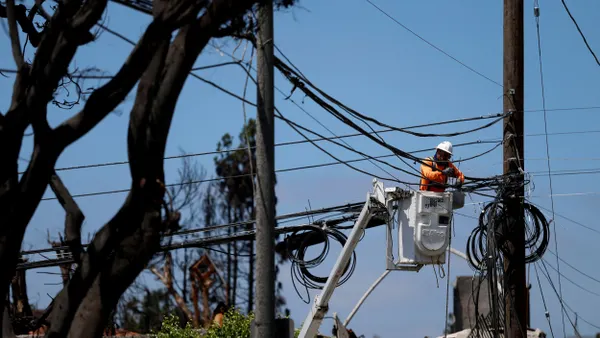 A utility worker repairs power lines