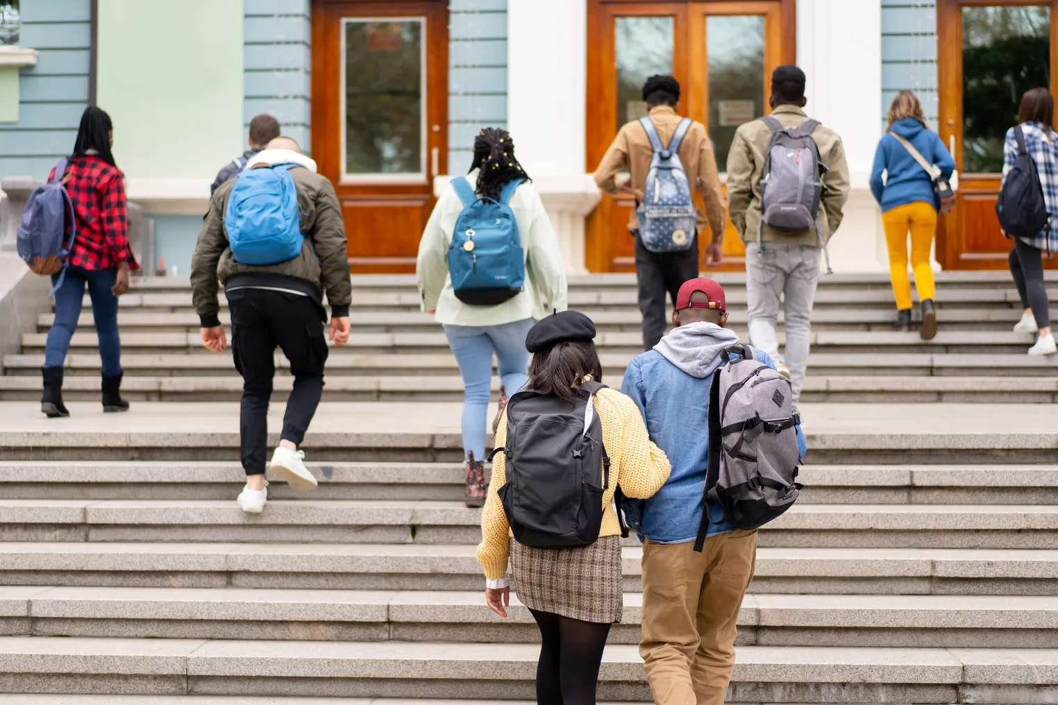 College students climb up the stairs to a campus building.