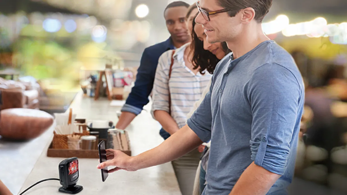 A person using their phone to pay in a store checkout line