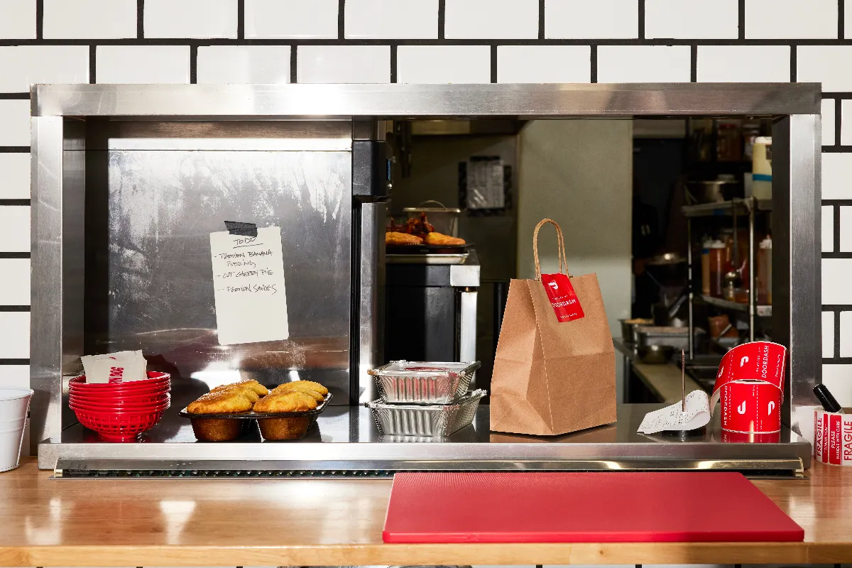 An image of a kitchen counter with DoorDash orders ready for pickup.