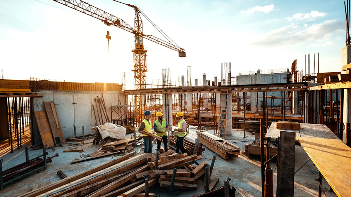 Building contractors analyzing blueprint at construction site