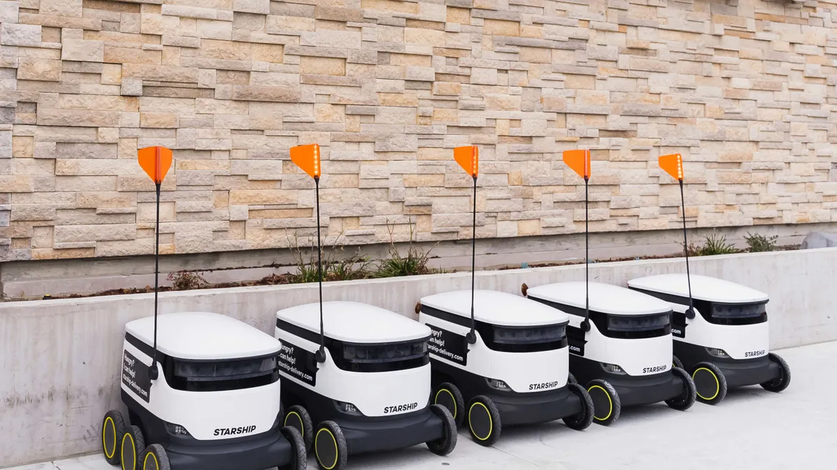 Five delivery vehicles outside of a store.