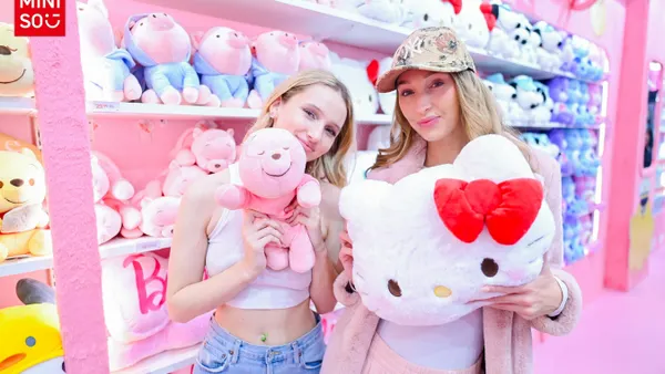 Two customers holding Sanrio plushies from the Times Square store.