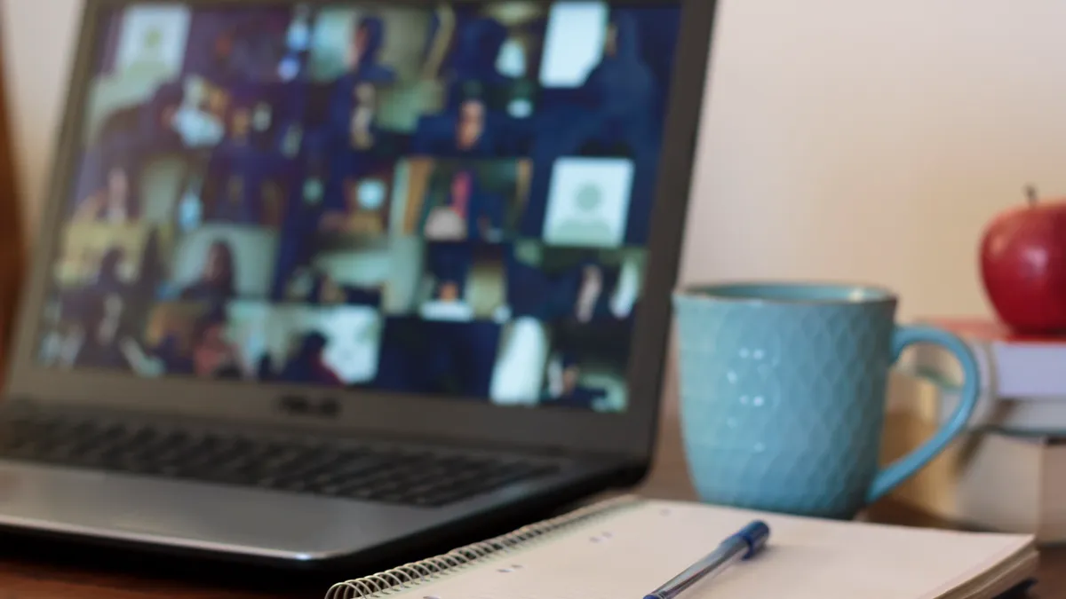 A notepad sits next to a laptop computer.