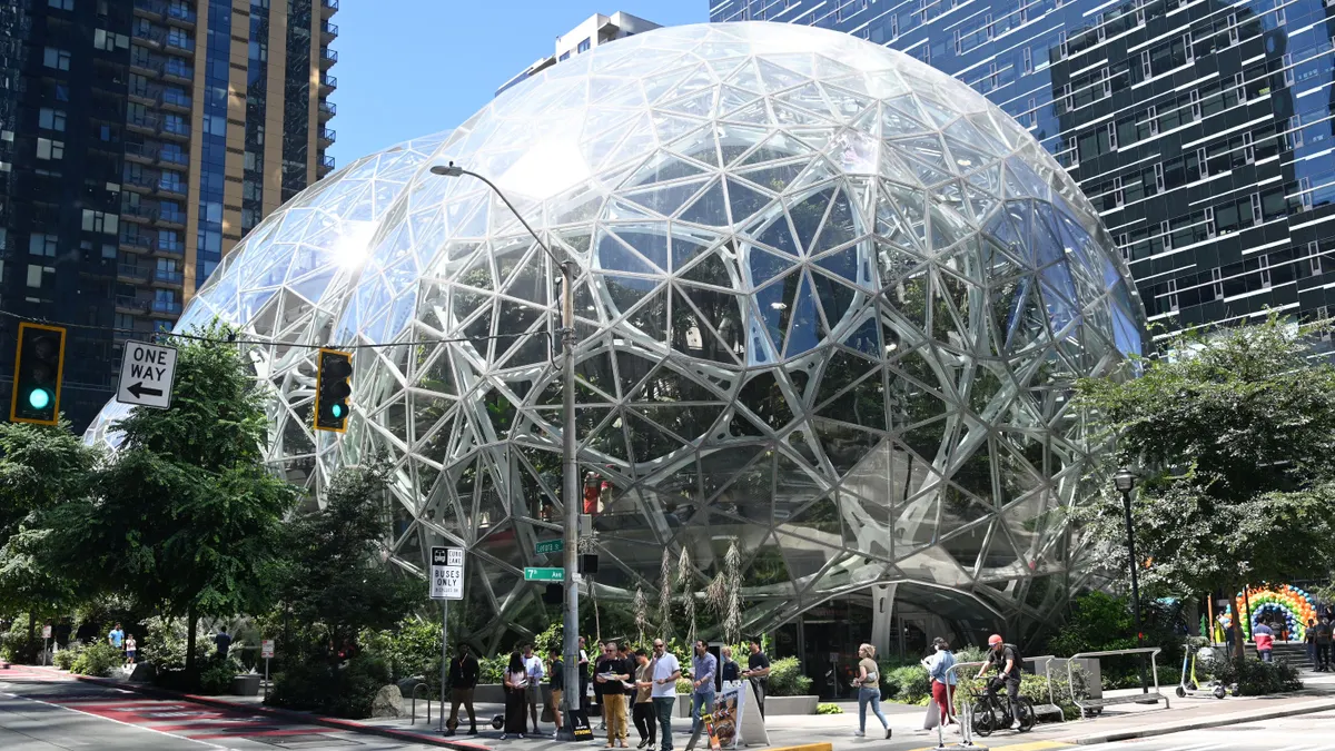 People walk in front of an art sculpture near the Amazon head office in Seattle.
