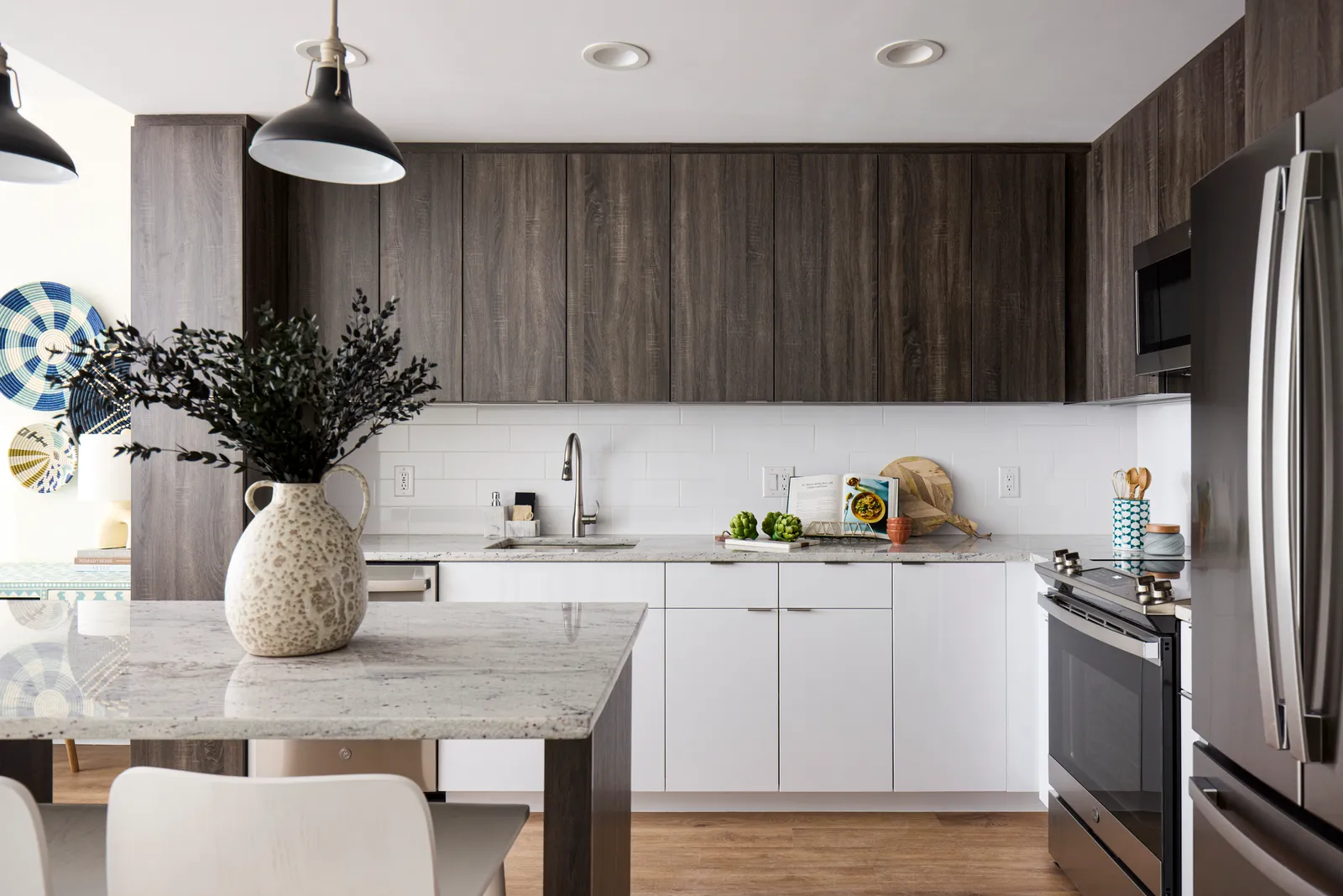 A kitchen with an island counter and dark wood cabinetry.