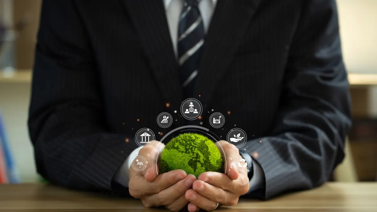 Businessman holding green world ball with Esg icons.Ethical and sustainable investing.