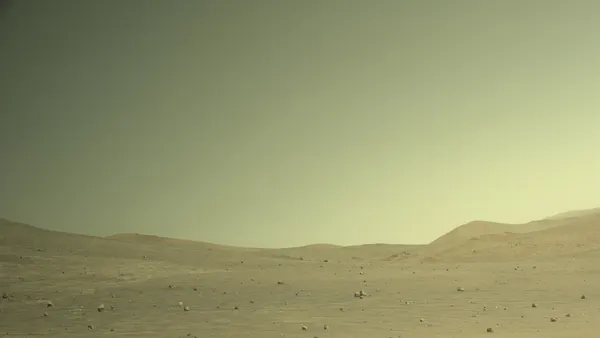A picture of a desolate, empty space on Mars with brownish dirt.