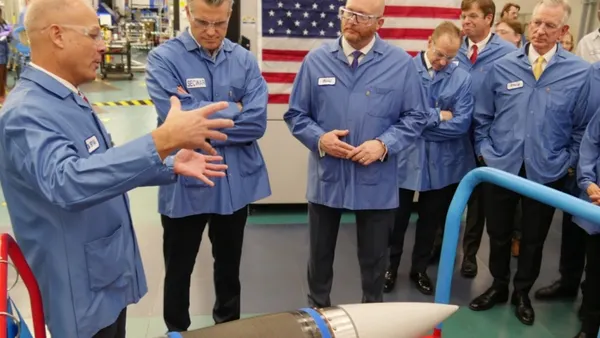 Six people wearing blue protected coats and goggles