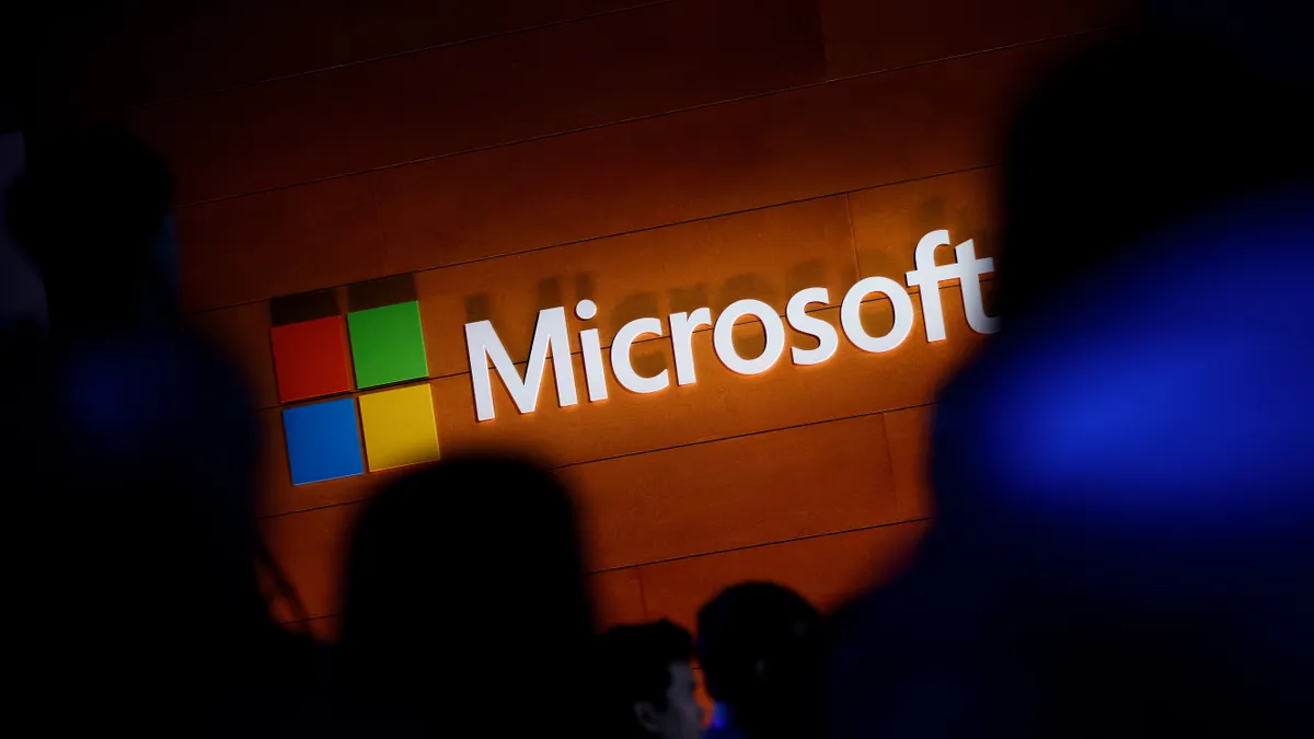 Microsoft's logo displayed on a wall, surrounded by shadows