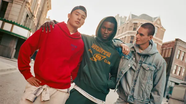 A trio of young models lock shoulders while walking down the street in an ad for American Eagle