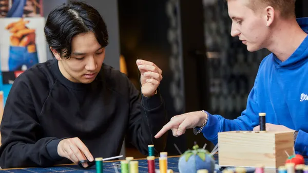 Two people participating in Levi's Wear Longer Project, which teaches students how to repair clothing items.