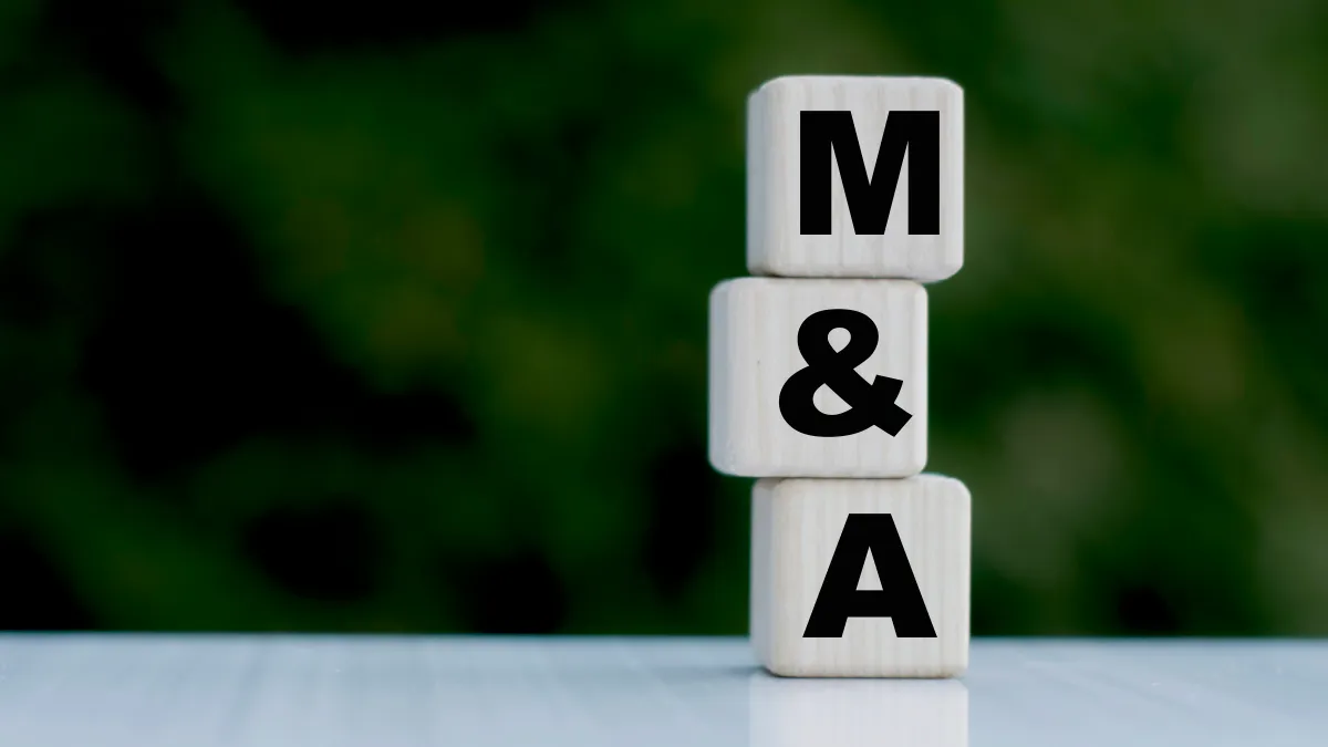 The concept of the word M&A on cubes on a beautiful green background. Business concept