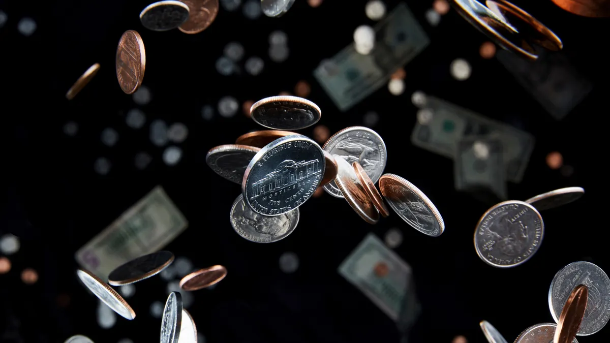 Studio shot of falling coins that appear to defy gravity in the air represent the economy and finance with a nickel in focus