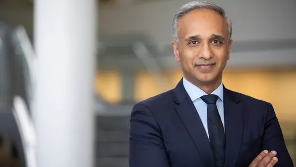 A man dressed in a suit looks at the camera in this headshot.
