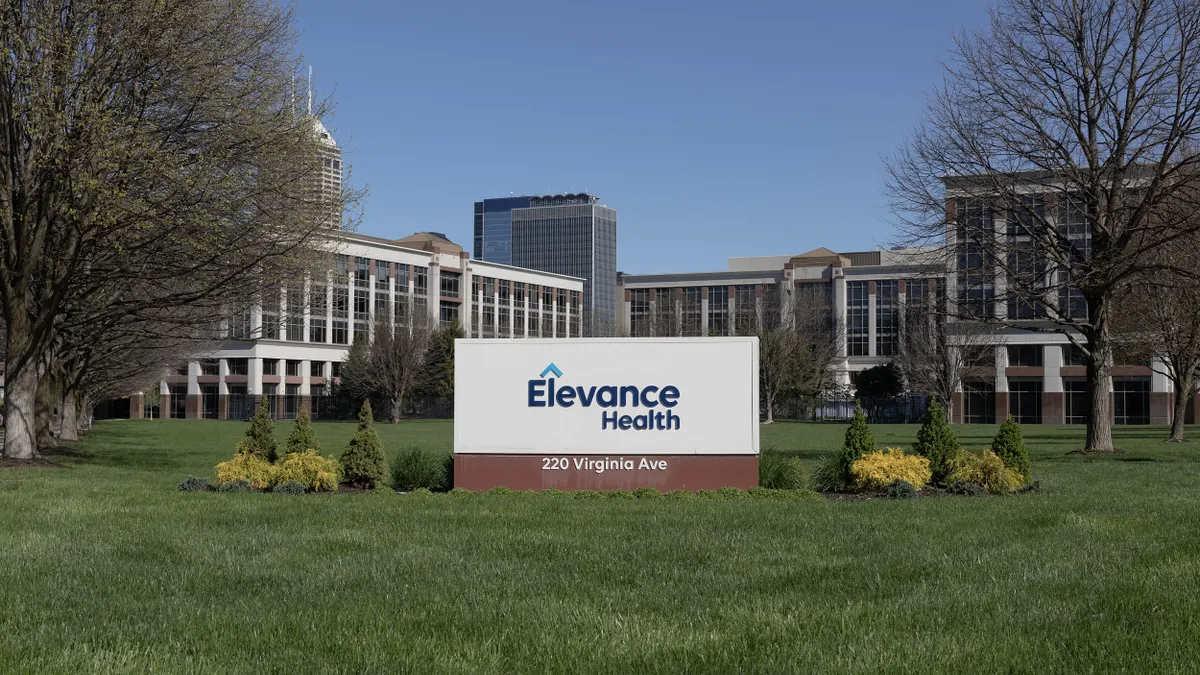 A sign reading 'Elevance Health 220 Virginia Ave' in front of a large office complex on a clear day.
