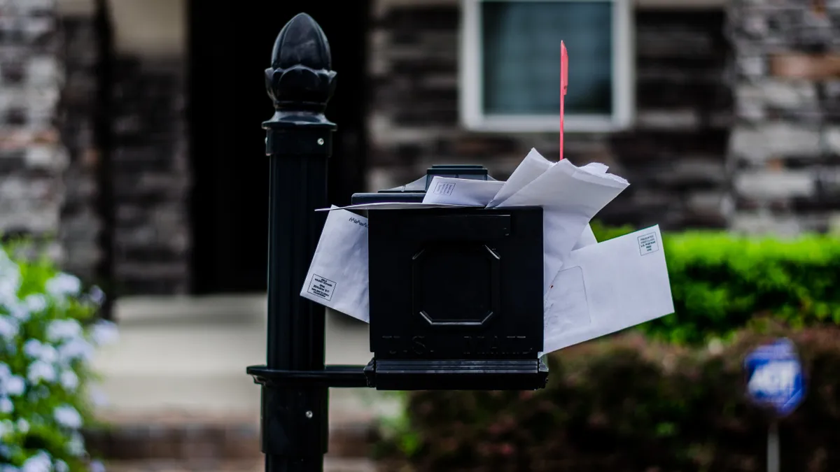 A mailbox is overflowing.