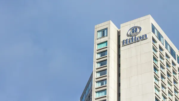 The exterior of a hotel shows a Hilton logo.