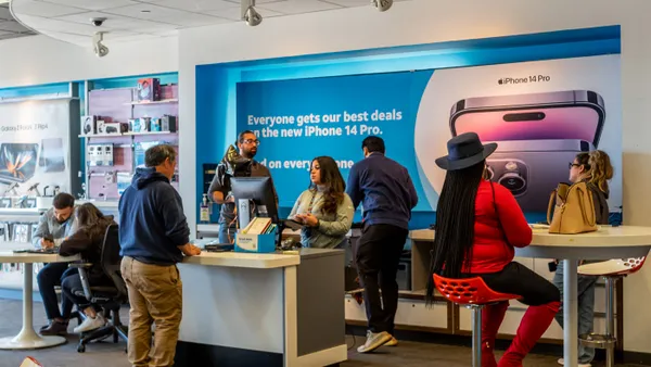 Customers speak with employees in a store.