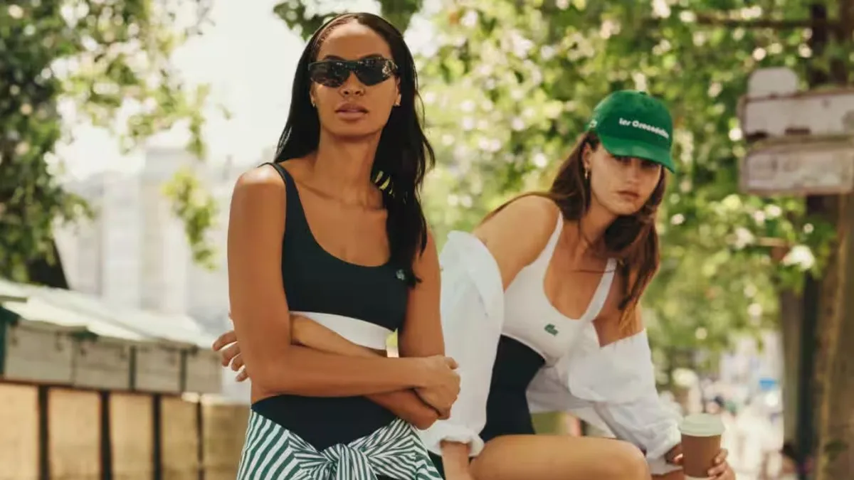 Two people wearing casual Lacoste and Bandier branded tennis athleisure apparel pose outdoors.