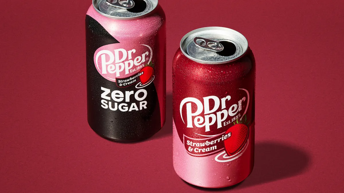 Open cans of Zero Sugar Dr Pepper Strawberries & Cream and Dr Pepper Strawberries & Cream on a burgundy background