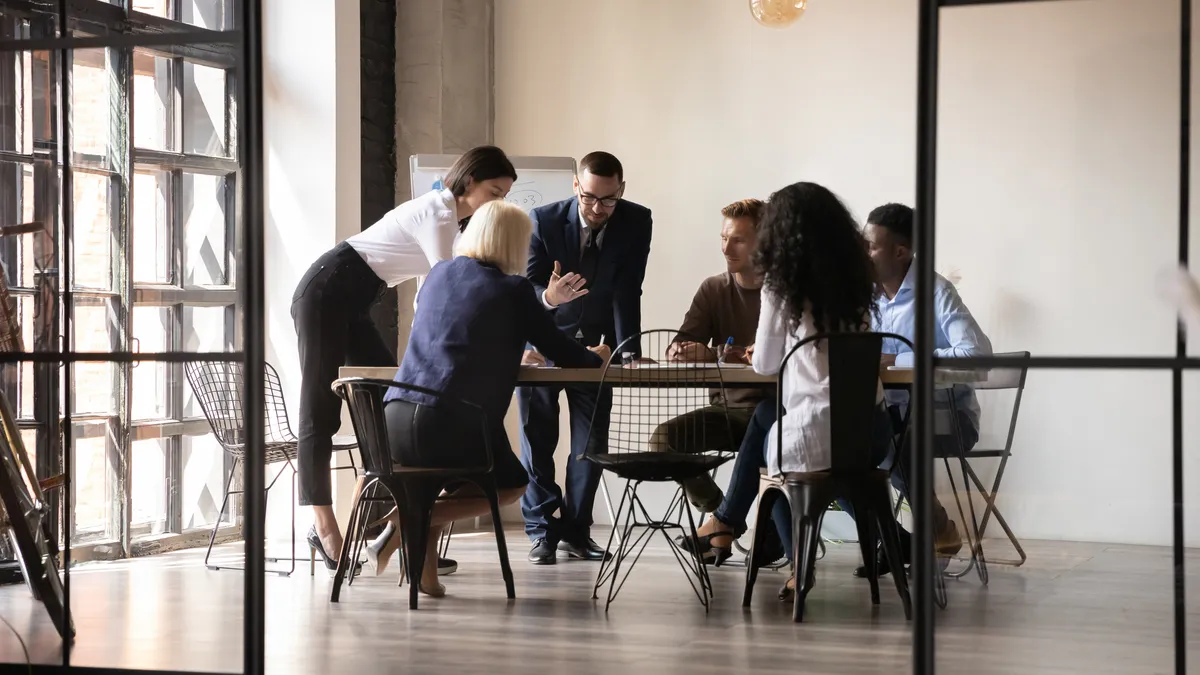 Diverse employees team engaged in teamwork in modern boardroom