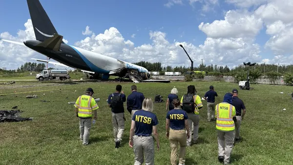 People approach the wreckage of an Amazon aircraft.