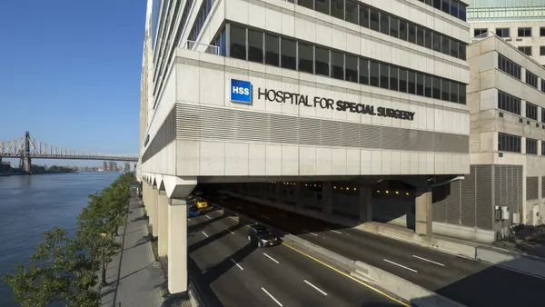 An exterior shot of a building stretching over a road next to a river, with the words "Hospital for Special Surgery" on the side.