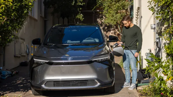 A man charging his electric vehicle.
