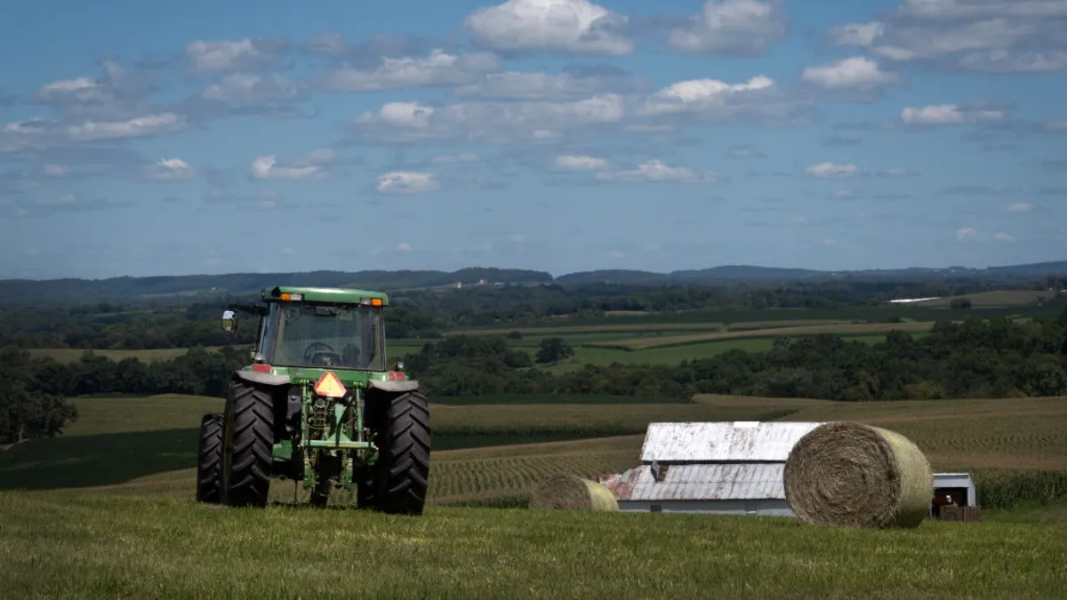 A tractor moves through a farm field