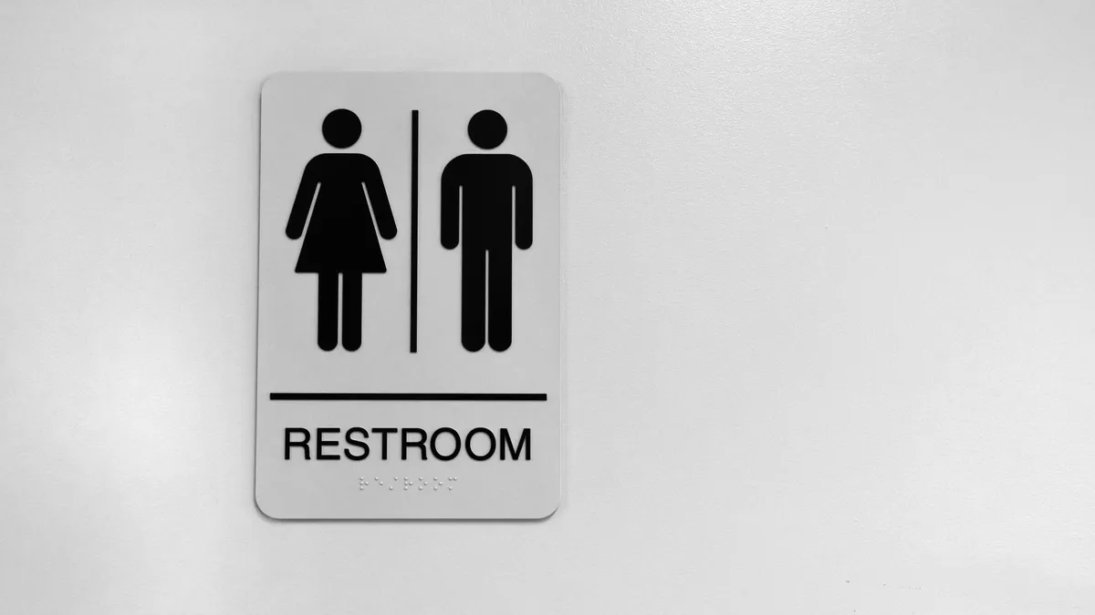 An image of a black and white public restroom sign.