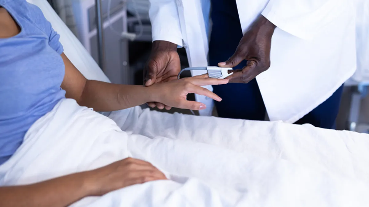 A doctor puts a pulse oximeter on a patient's finger