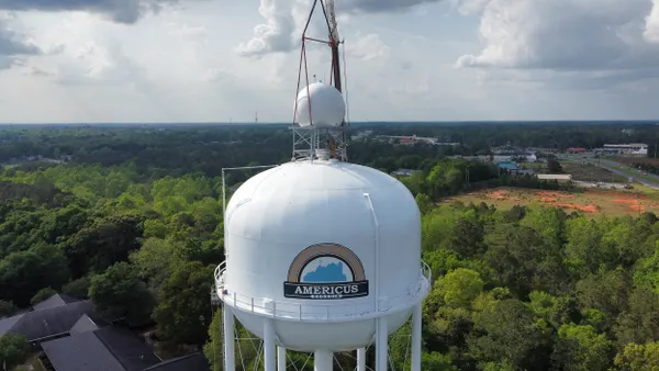 A radar device installed on top of a water tower with a graphic that contains the words "Americus, Georgia" and "Touch America's Heart."