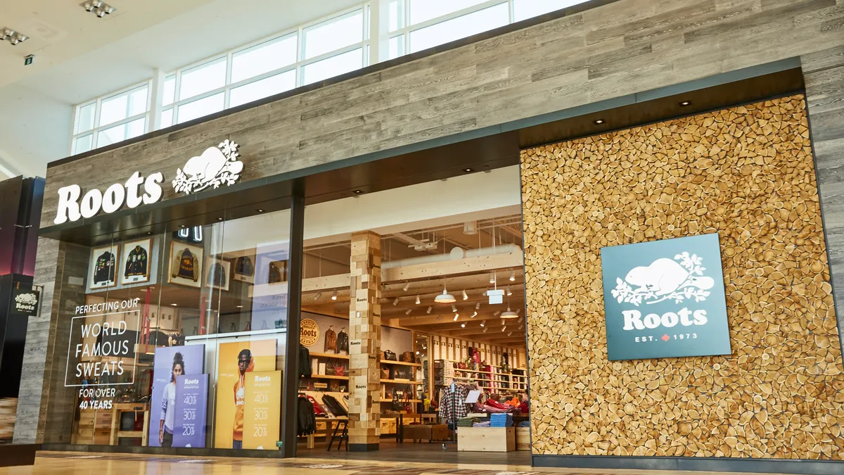 A Roots storefront inside a mall, with cork and wood detailing.