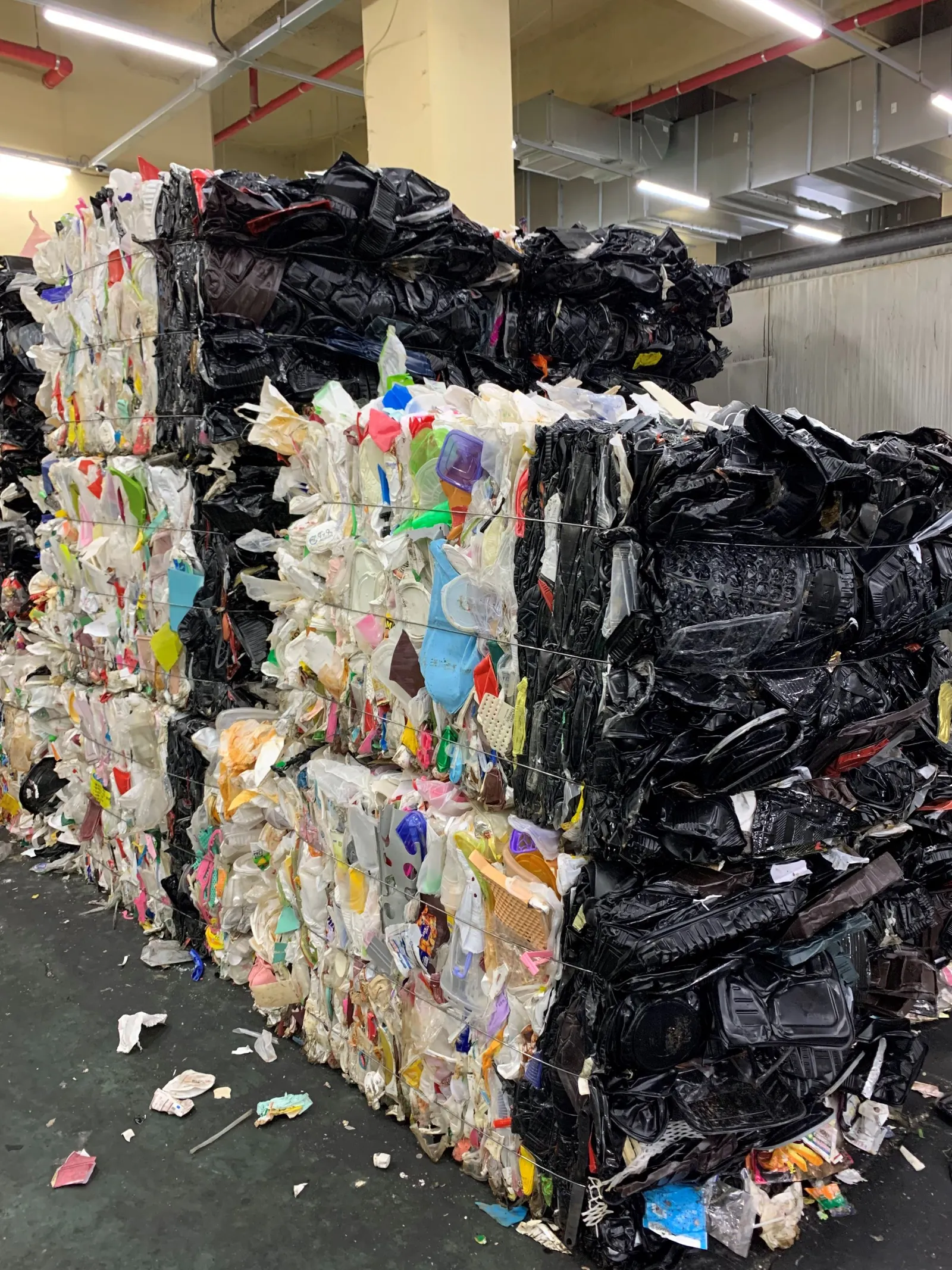 A bale of mixed plastic packaging with a portion of it containing black plastics.