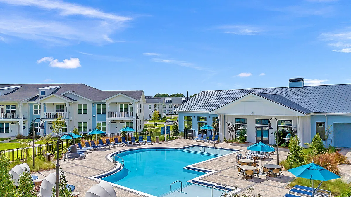 Two-story apartment building with a pool in the foreground