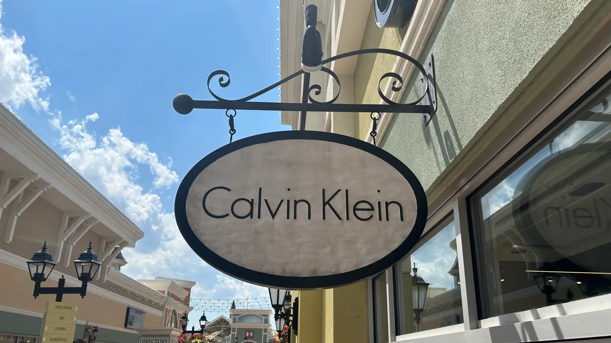 A Calvin Klein sign hangs outside a Calvin Klein outlet store.