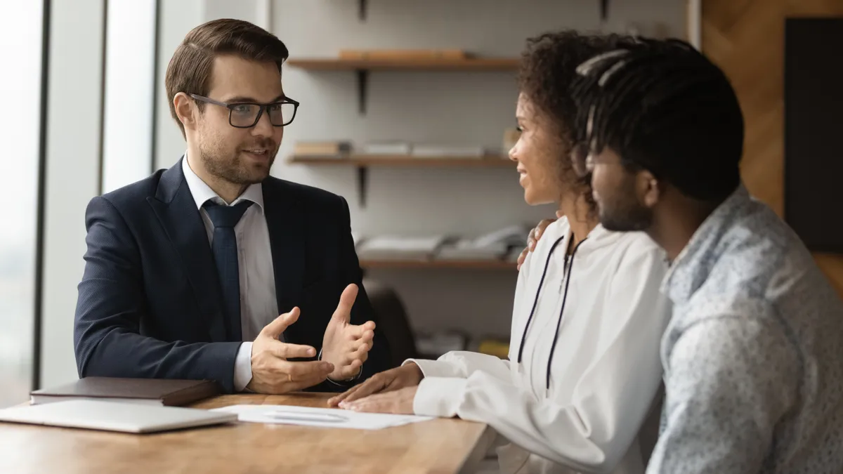 A couple talking to a banker at a table