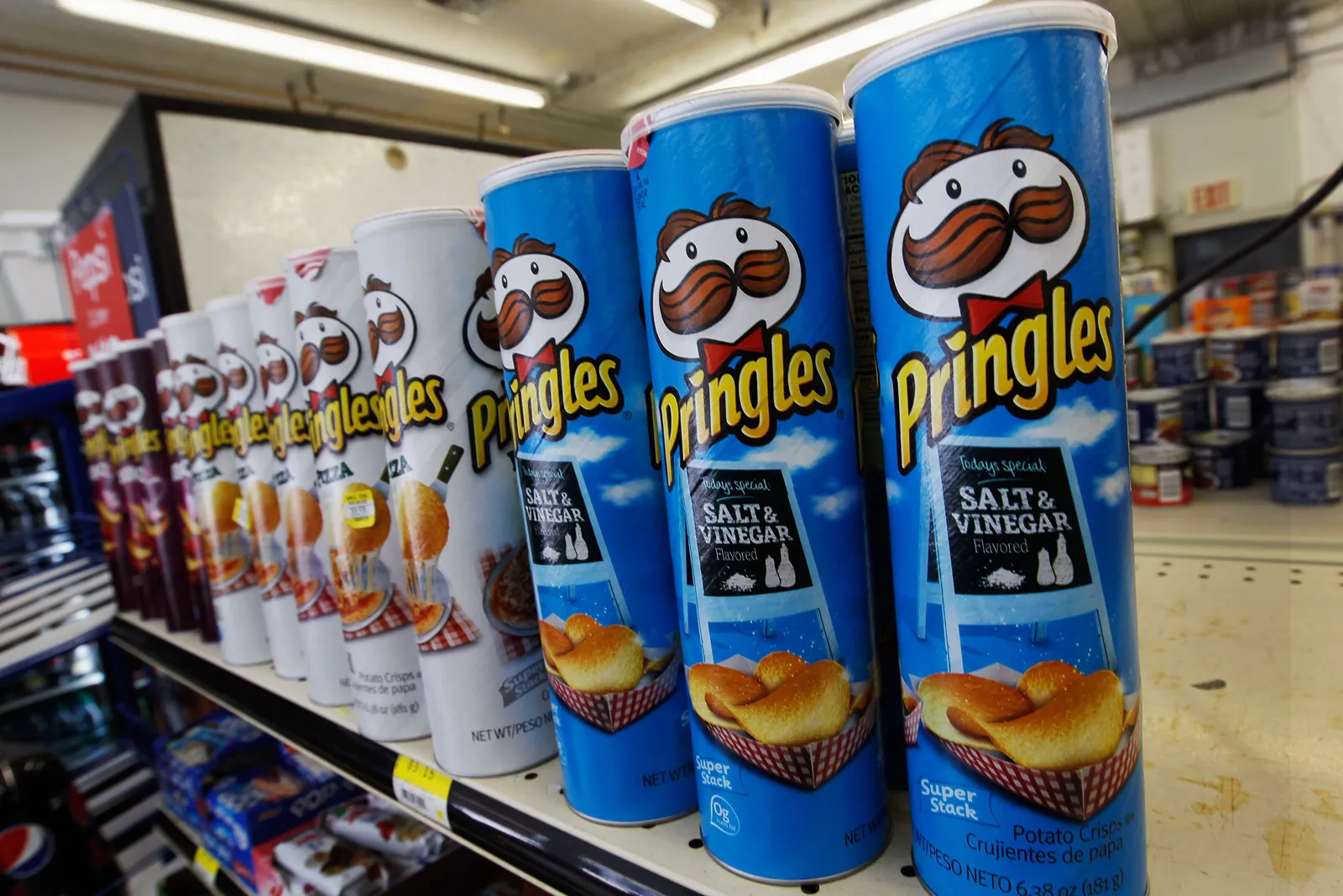 Tins of different flavored Pringles lined up in a convenience store