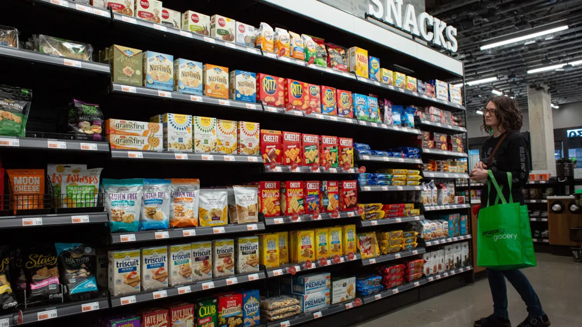 A shopper browses the snack aisle in a grocery store