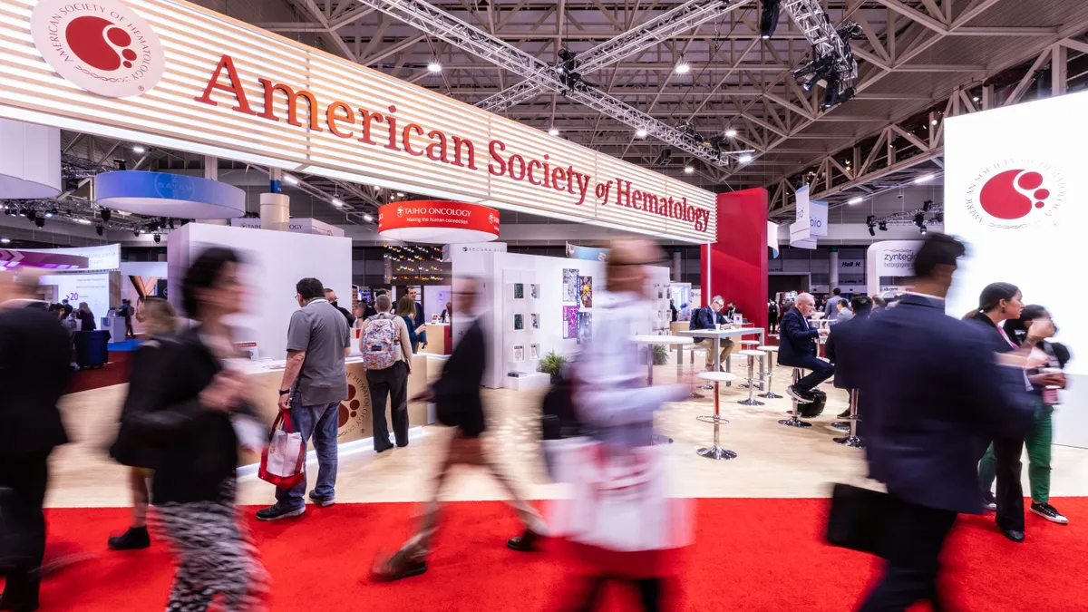 Attendees of the American Society of Hematology's annual meeting walk across a conference hall in December 2022.