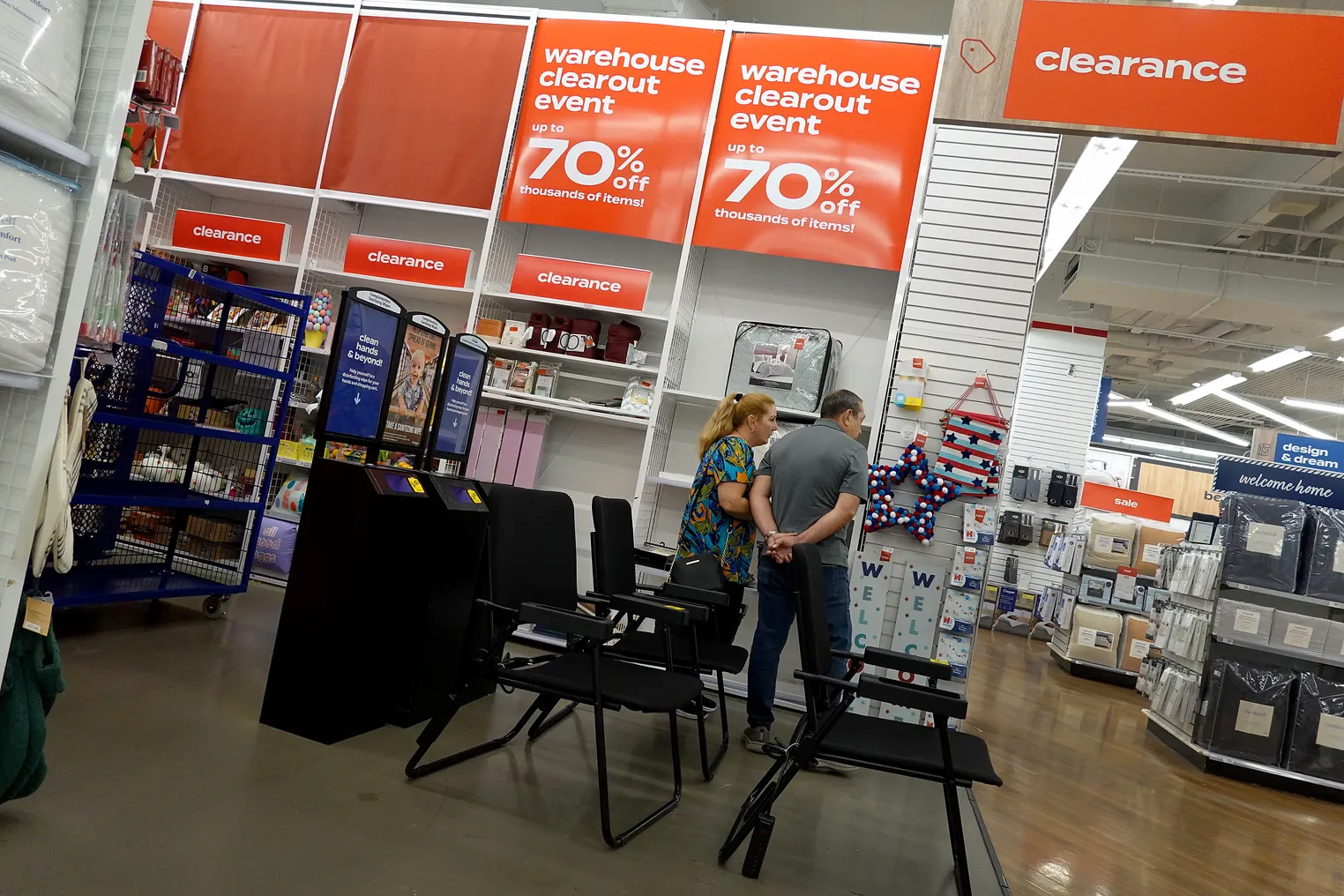 Image of customers shopping in a Bed Bath & Beyond store with sale signs visible.