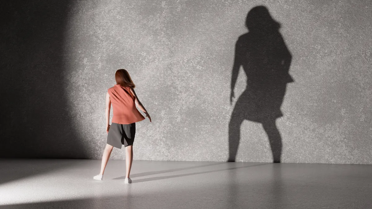 woman standing in front of wall casting shadow