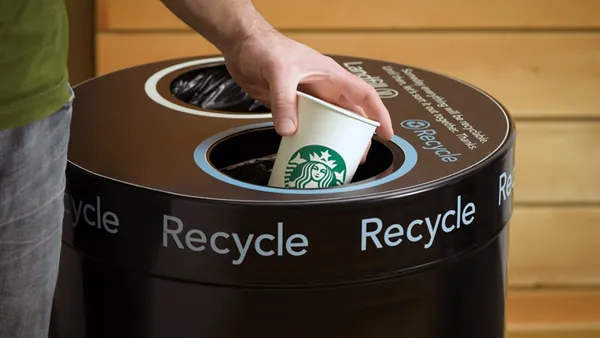 Starbucks cup going into a recycling bin