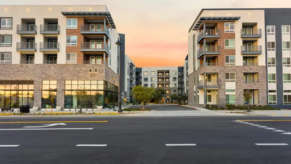 Brown and white mid-rise apartment community.