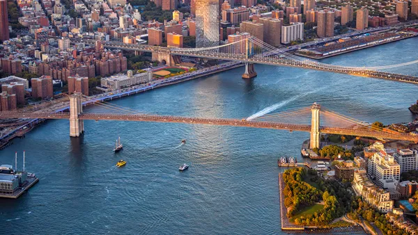 an aerial view of the Brooklyn and Manhattan Bridges spanning the East River between Brooklyn and Lower Manhattan in New York City.